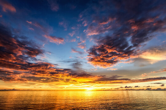 Sun setting over the equator in the Raja Ampat islands of West Papua in the Halmahera sea, West Papua, Indonesia