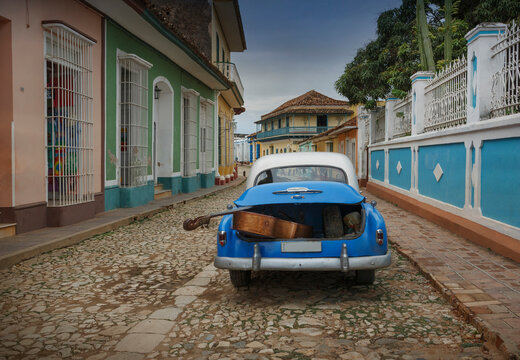 Old American car with double bass in trunk in colonial street, Trinidad, Sancti Spiritus, Cuba