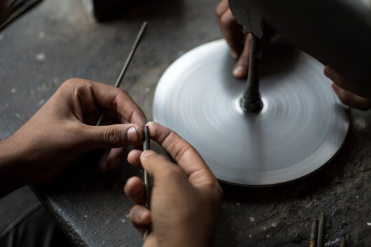 Close up of hands polishing rubies in workshop, Jaipur, Rajasthan, India