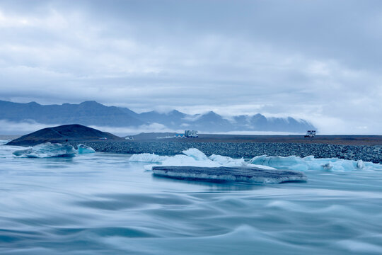 Mountain range and icebergs floating on glacial river lagoon, Jokulsarlon, Iceland