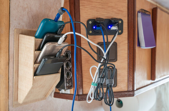 Rack for loading smart phones. View of cell phones, plugs and wires