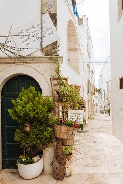 Rustic baskets and chairs displayed outside shop on corner of alley, Locorotondo, Puglia, Italy
