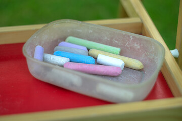 Colorful crayons for drawing on the blackboard,are in a plastic container