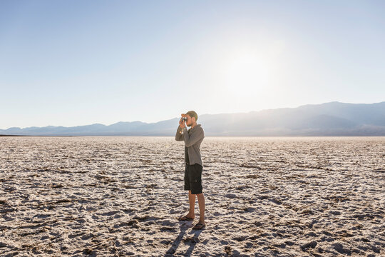 Man taking photograph, Badwater Basin, Death Valley National Park, Furnace Creek, California, USA