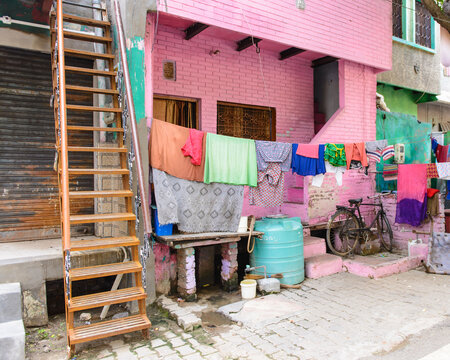 Pink building with colorful laundry hanging outside in a poverty district of Varanasi, India
