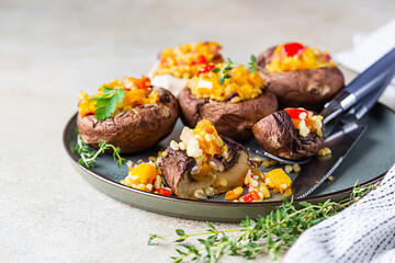 Baked stuffed portobello mushrooms with bulgur pilaf and chopped vegetables. Delicious and nutritious vegetarian dish. Selective focus.