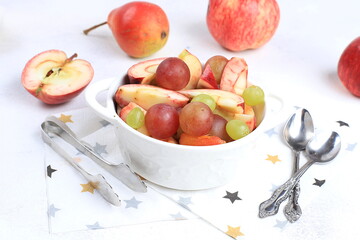 Healthy breakfast, food for children, fruit salad with apples, pears, grapes on a bright table. The concept of healthy and natural food, lifestyle, promotes weight loss, selective focus