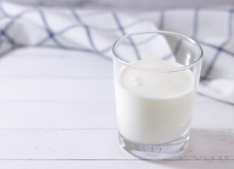 Homemade fermented milk drink in a glass of kefir on a light background. Place for your text.