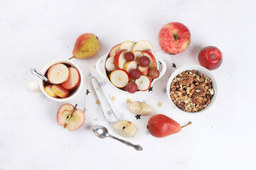 Healthy breakfast, food for children, fruit salad with apples, pears, grapes on a bright table. The concept of healthy and natural food, lifestyle, promotes weight loss, top view