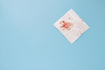 blood on a paper napkin isolated on a blue background