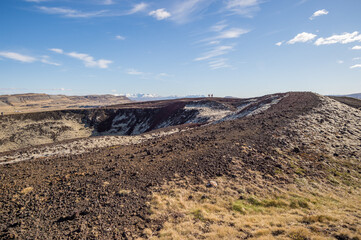 Group of people standing at the top of the Grabrok crater in Iceland.