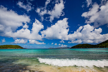 Passing ferry boat creates a small wave breaking on the shore of St John