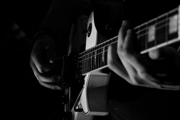 Guitarrista, guitarra sendo tocada, preto e branco, close mãos.