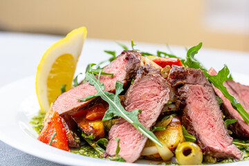Fried vegetables with slices of roast beef are on a plate