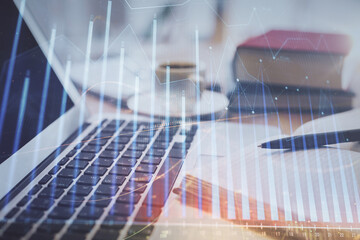 Double exposure of financial chart drawing and desktop with coffee and items on table background. Concept of forex market trading