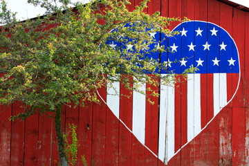 American flag in heart shape on barn