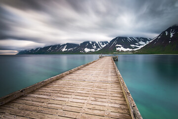 View of wooden pier against snowy mountains