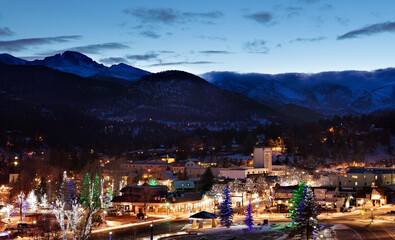 View of illuminated Estes Park town with Longs Peak mountains in background
