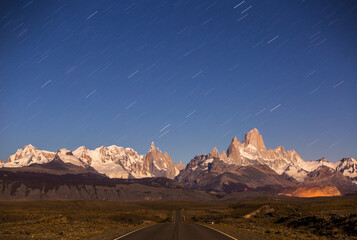 View of star trail over road with Mount Fitzroy in background