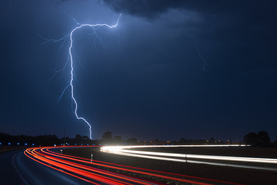 Light trail against lightning at night