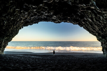 Rear view of girl standing on beach during sunset