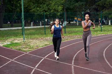 A black and Caucasian women jogging in the street in a specialized place. Sport - is life