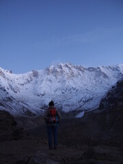 Fototapeta premium A climber standing in front of a snow-covered rock in the early morning, ABC (Annapurna Base Camp) Trek, Annapurna, Nepal