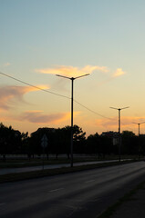 Street lamps and buildings against the setting sky