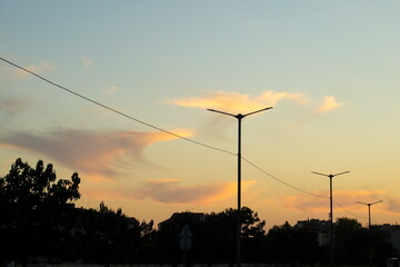 Street lamps and buildings against the setting sky
