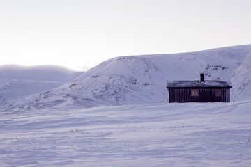 View of cottage on snow covered landscape