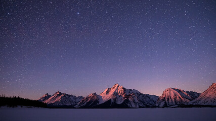 Scenic view of Teton Range against starry sky