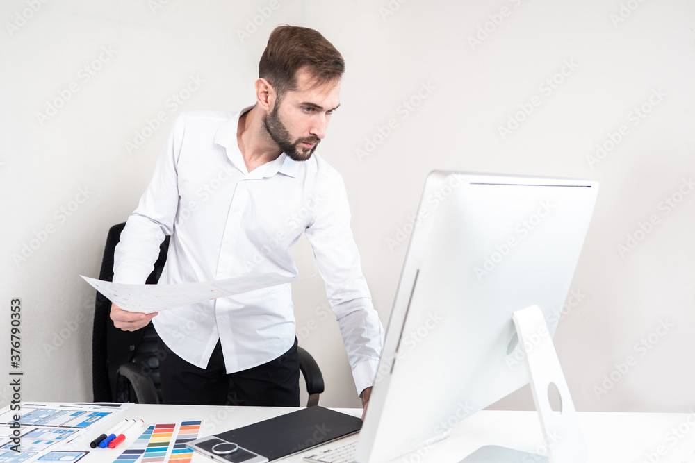 Poster mobile app designer. the man is working on the interface of the program for a smartphone. the design