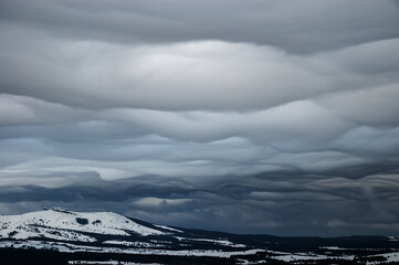 Grey wavy landscape clouds over the winter highlands