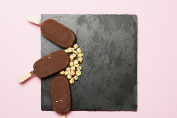 top view of chocolate ice cream on slate plate with hazelnuts. flat lay