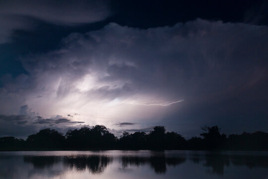 Scenic view of lightning over lake at night