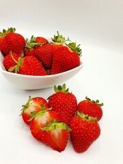 Fresh strawberries in a bowl on a white background. 