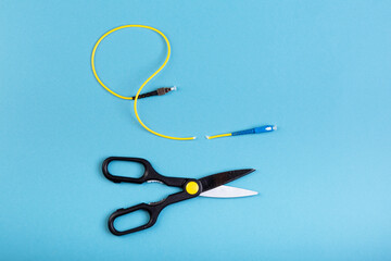 Destroy optical SC fiber by scissors. Isolated on blue