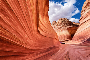 Side view of man leaning on rock formation