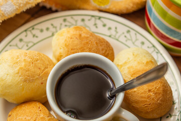 Uma xícara de café com pães de queijo.