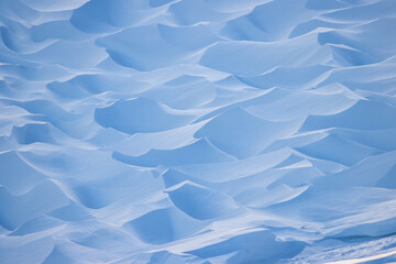 Snow texture. Wind sculpted patterns on snow surface. Wind in the tundra and in the mountains on...