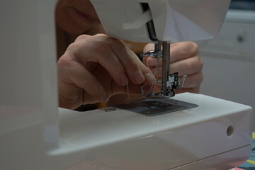MANOS DE MUJER COSIENDO A MAQUINA