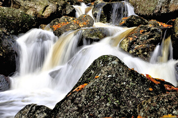 Fast-flowing stream plunging through rugged bed of granite bounders, Harvard Brook, White Mountains, New Hampshire.