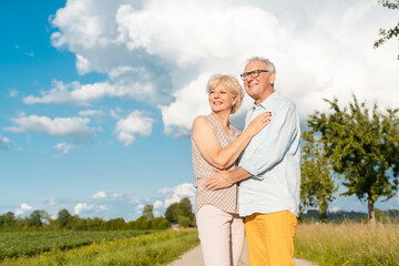 Senior couple in summer landscape looking into the future together
