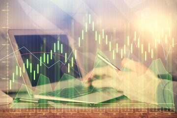 Double exposure of man's hands holding and using a digital device and forex graph drawing. Financial market concept.