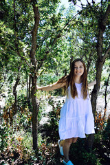 Girl in white dress running through trees