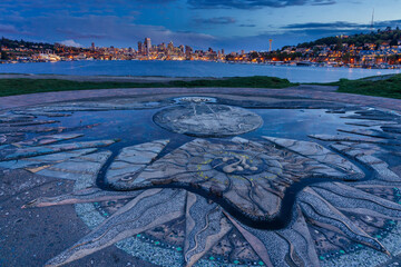 Concrete sundial in Gas Works Park with city in background during sunset