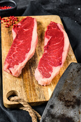 Sirloin steak on a cutting Board. Organic beef meat. Black background. Top view