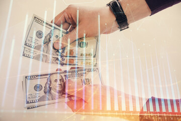 Multi exposure of financial graph drawing hologram and USA dollars bills and man hands. Analysis concept.