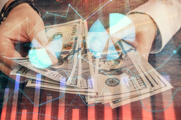 Multi exposure of financial graph drawing hologram and USA dollars bills and man hands. Analysis concept.