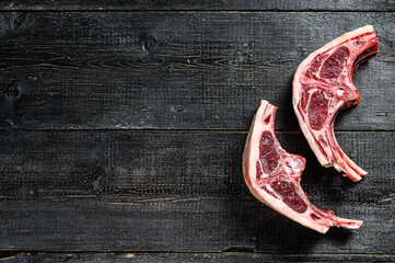 raw lamb chops fresh cut . Black background. Top view. Copy space
